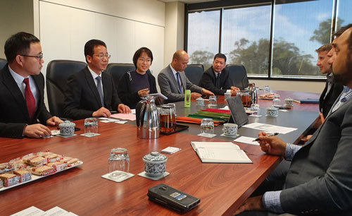 Group of business people sitting around table in an office having a formal meeting