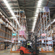 warehouse with forklift being driven around shelves of goods