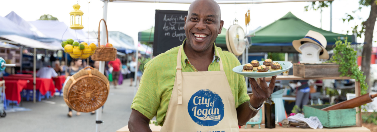 Chef Ainsley smiling and holding a plate of food