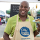 Chef Ainsley smiling and holding a plate of food