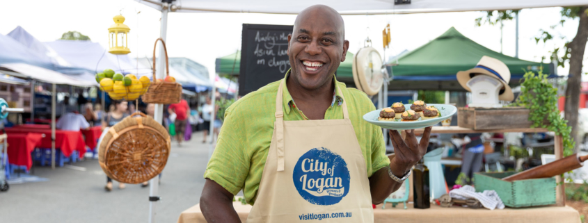 Chef Ainsley smiling and holding a plate of food