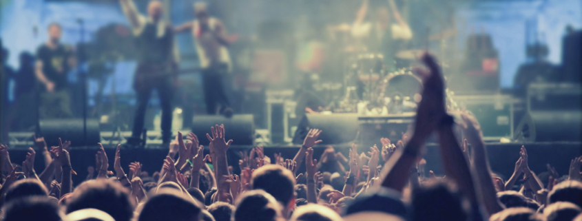 Crowd clapping in front of stage with musicians performing