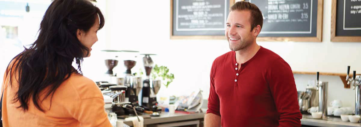 Man and woman smiling at each other in a cafe