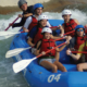 Seven people in whitewater raft paddling down rapids
