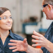 Two factory workers smiling and chatting