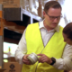 Man checking packaging with female in warehouse