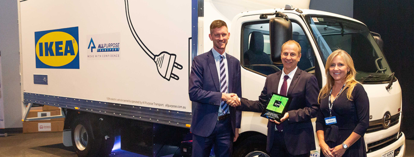 Woman smiling and two men shaking hands in front of a IKEA truck