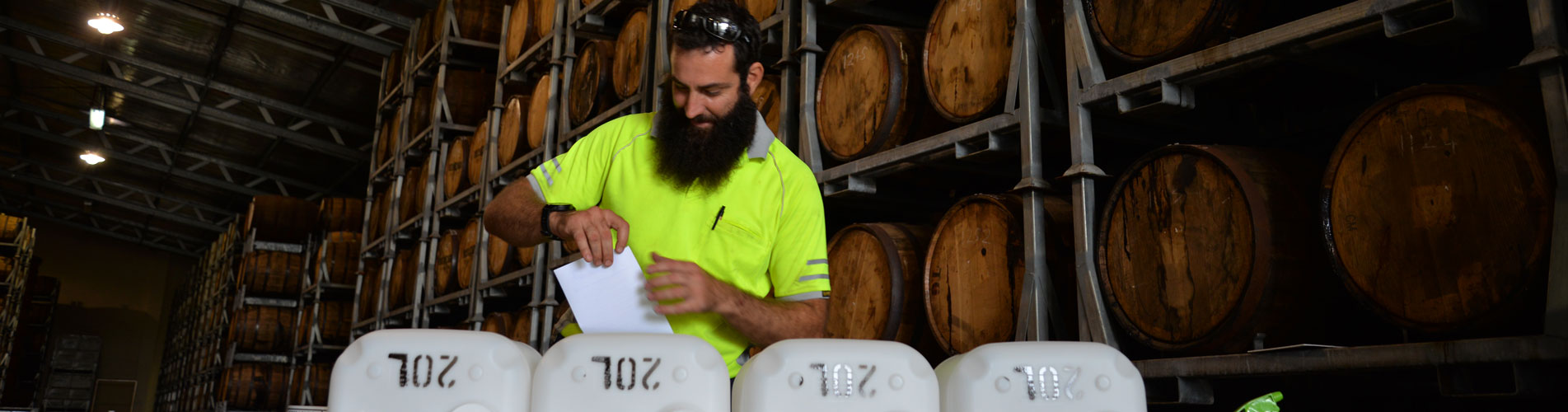 Factory worker applying labels to 20L cubes in rum factory