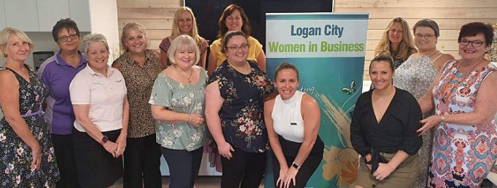 woman standing in front of 'Logan City Women in Business' banner