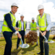 Contractor staff turning sod at future construction site