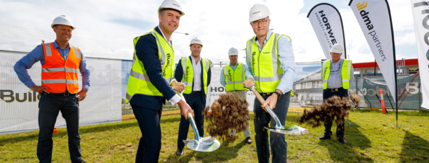 Contractor staff turning sod at future construction site