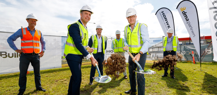 Contractor staff turning sod at future construction site