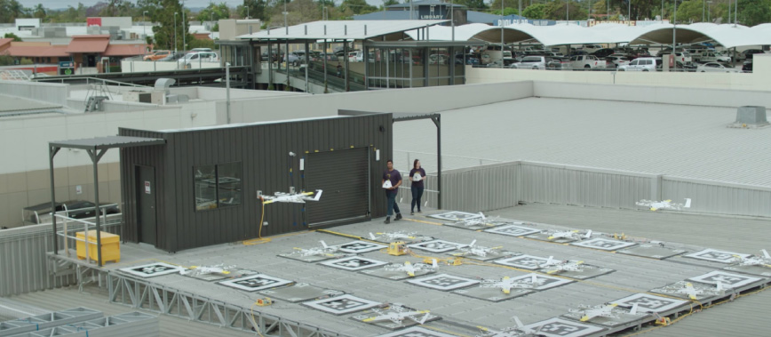 Wing drones launching from shopping centre roof