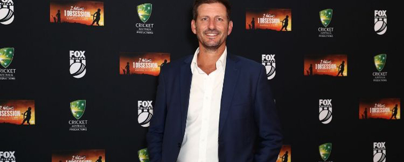 Michael Kasprowicz standing in front of a media wall