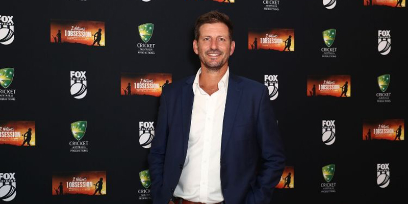 Michael Kasprowicz standing in front of a media wall