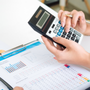 Image_an accountant using a calculator and showing charts and figure to a colleague.