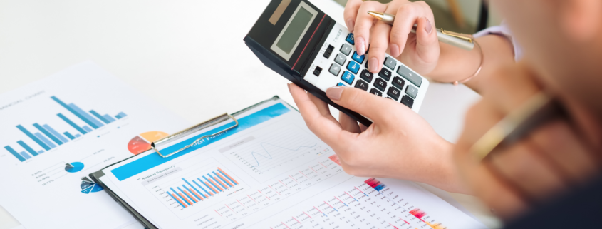 Image_an accountant using a calculator and showing charts and figure to a colleague.