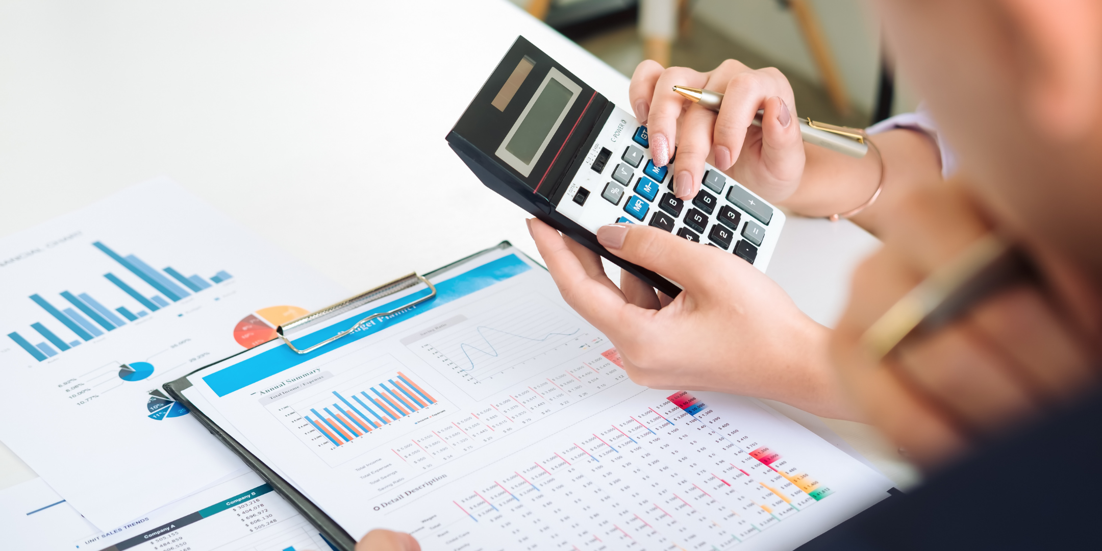 Image_an accountant using a calculator and showing charts and figure to a colleague.