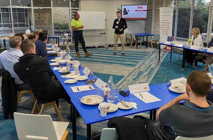 A group of people sitting around while someone is presenting