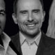 a black and white image of 2 men and a woman smiling