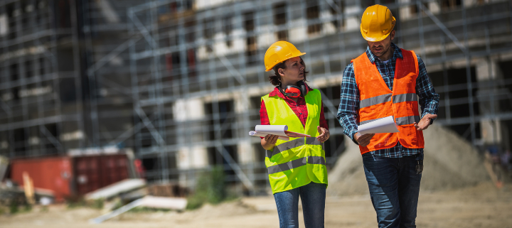 2 colleagues on site inspecting with high-vis vest and helmet