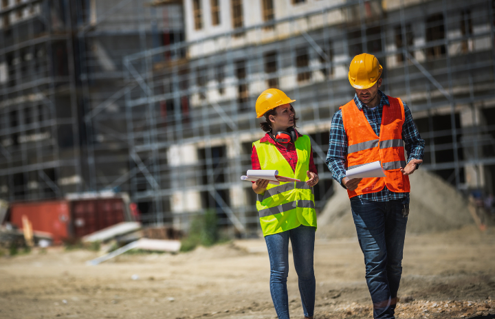 2 colleagues on site inspecting with high-vis vest and helmet