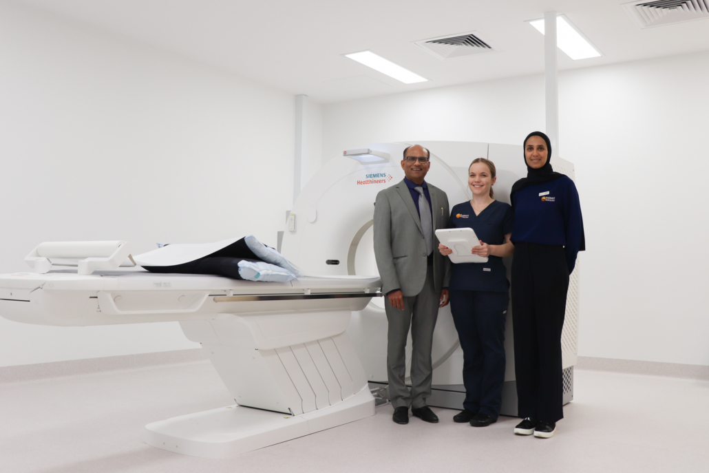 Dr with technicians standing next to a MRI machine