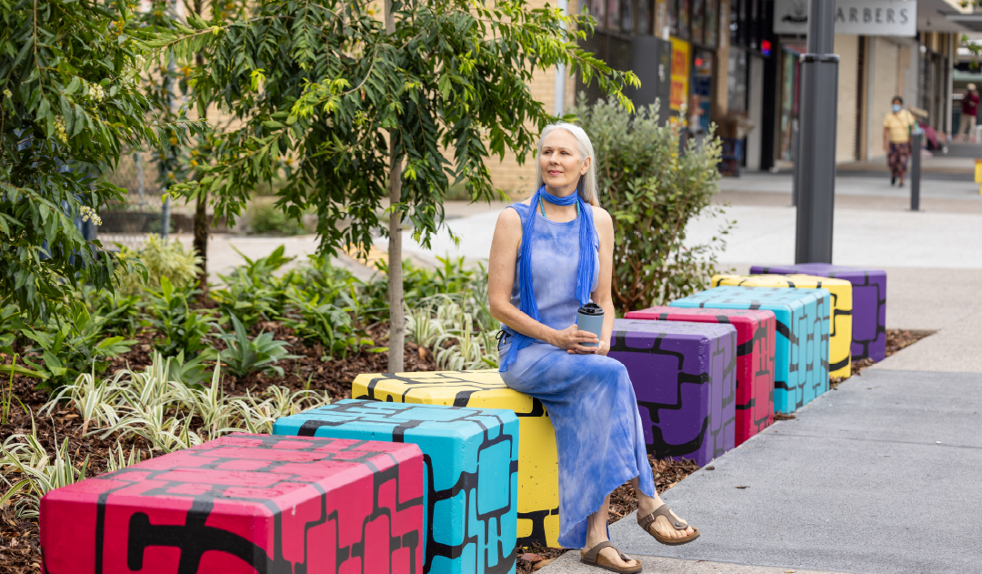Lady sitting on an artistic concrete block on Croydon Road