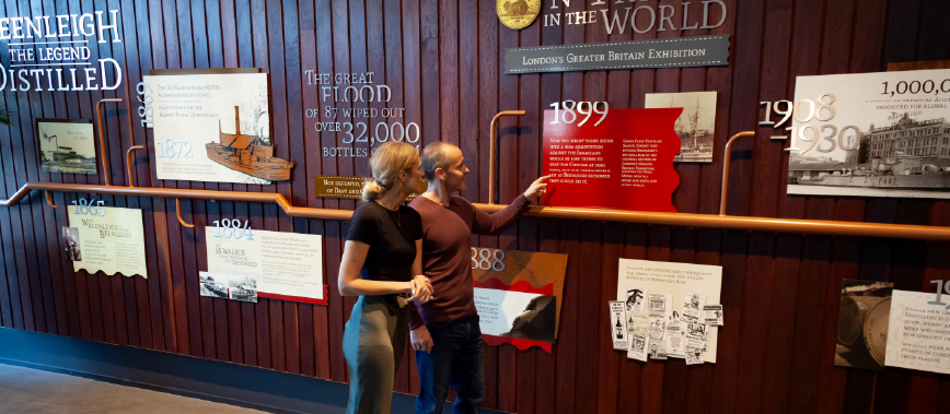 Couple walking and looking through the history wall at Beenleigh Artisan Distillery