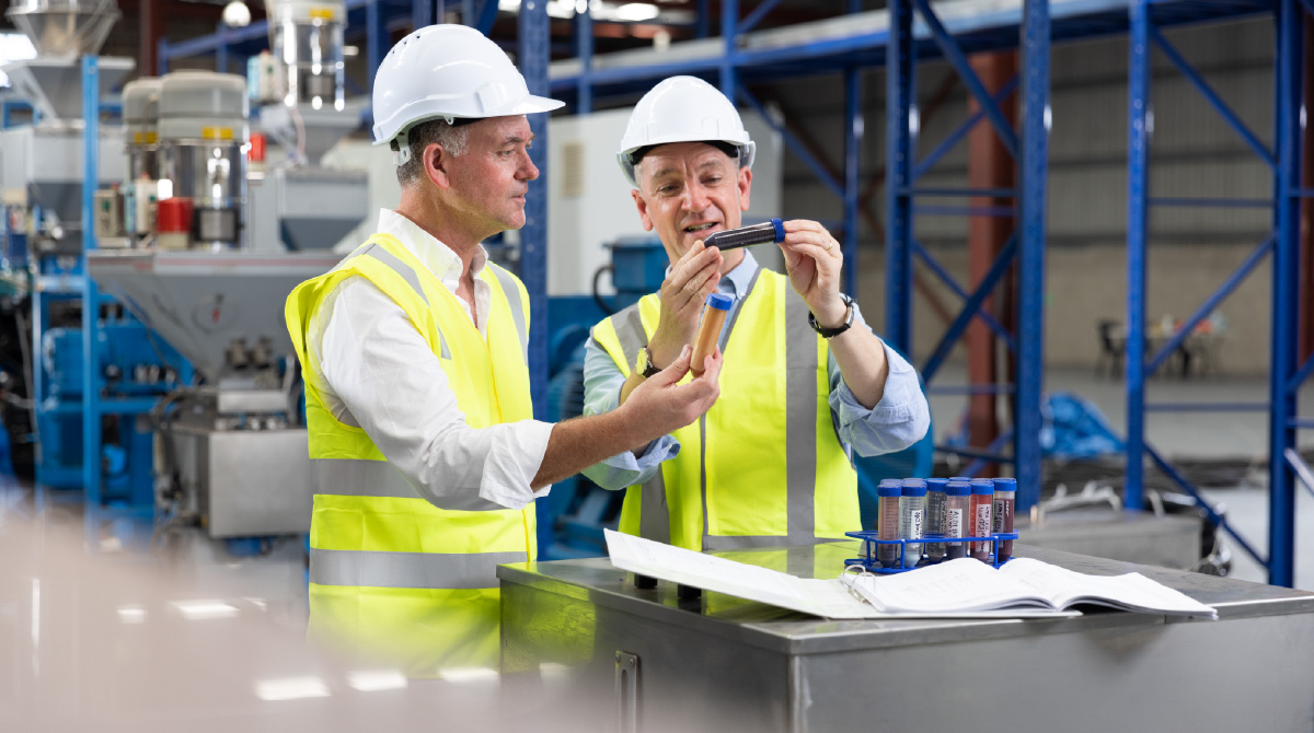 2 people looing at the recycled product in a syringe